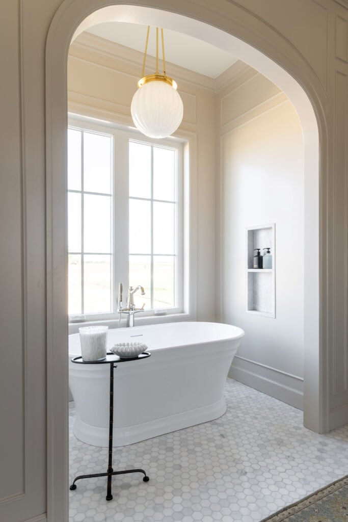 we went with a floor-mounted freestanding tub faucet with hand shower in polished nickel. The freestanding tub is perfectly placed in front of a large window to take full advantage of natural light. 