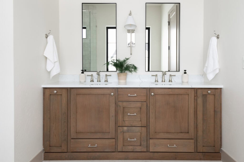 beautiful Bathroom Wall Sconce Lights above a double bathroom vanity in a custom home by Meg & Co