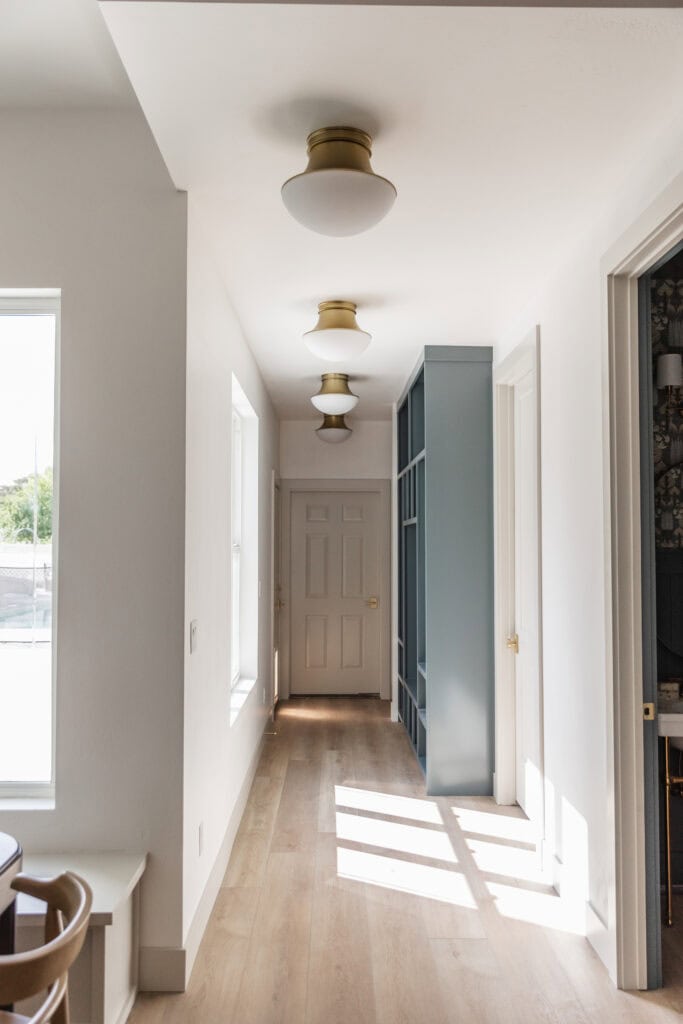 four Modern Flush Mount Ceiling Lights in Aged Brass installed in a spacious mudroom by Meg & Co