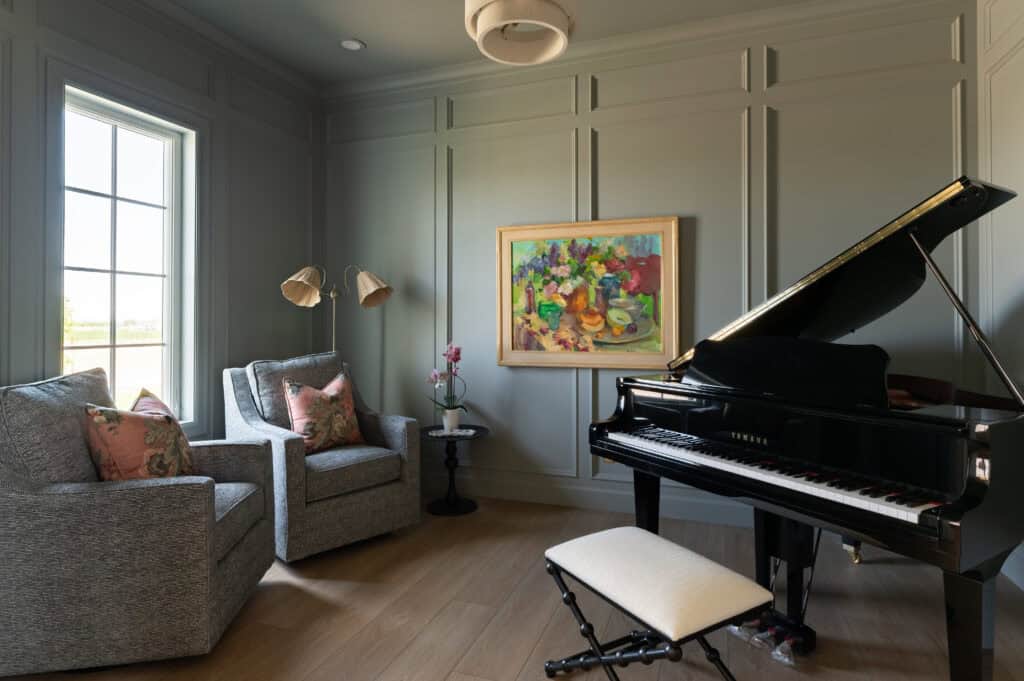 a photo of a color-drenched office, wainscoting, a grand piano and a large piece of art on the wall in a custom home by Meg & Co in Twin Falls Idaho