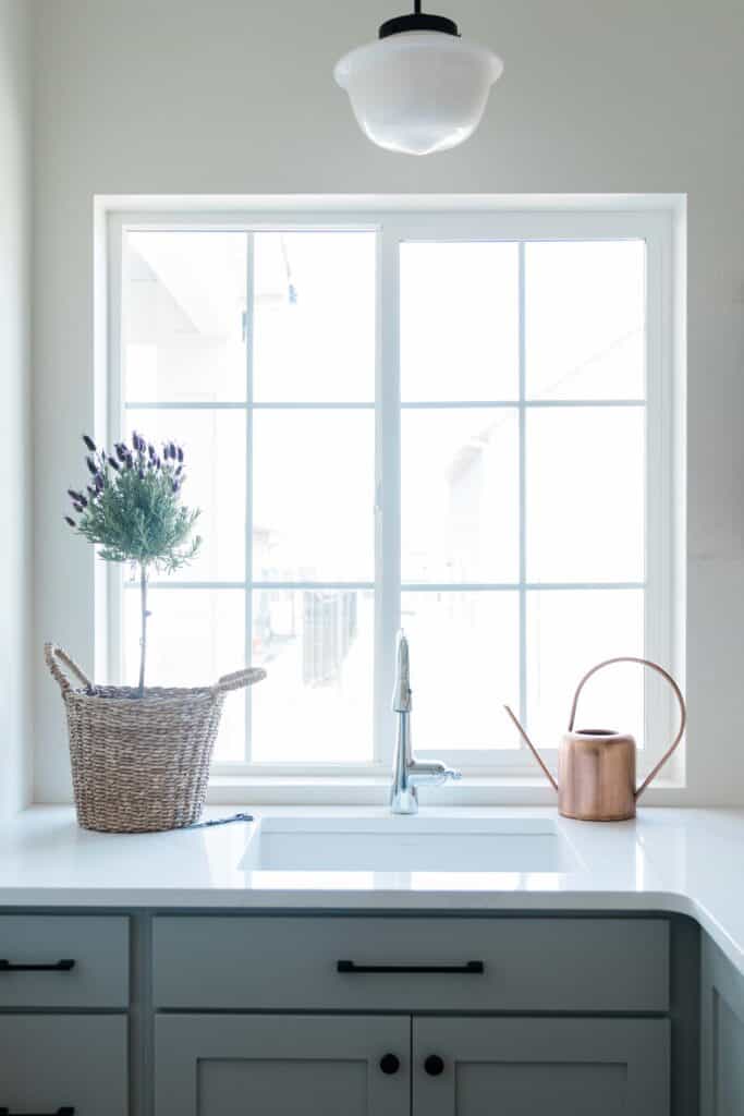 a photo of a Stylish Modern Schoolhouse Globe Light in a laundry room above the sink 
