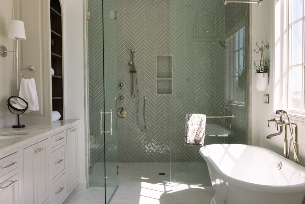 a beautiful bathroom with a freestanding tub that anchors the space
