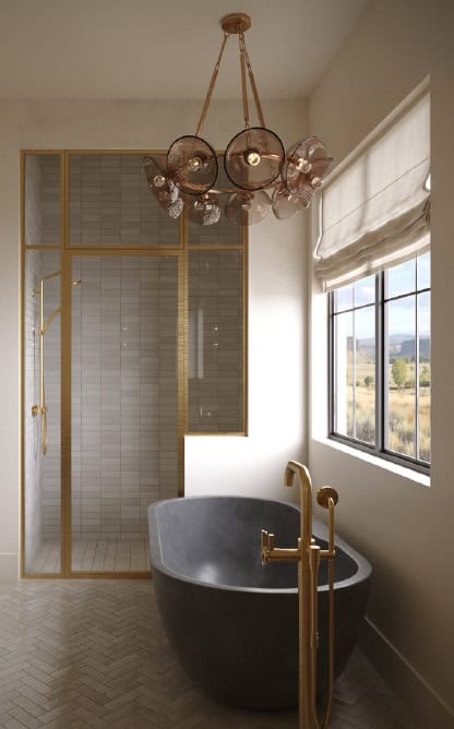 Primary Bathroom - Custom Home Hailey Idaho Primary bathroom in The Merrick featuring a freestanding concrete tub, glass-enclosed shower, brass fixtures, natural tile, and mountain views.